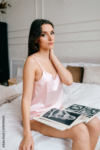 Beautiful elegant girl sitting in bed with book