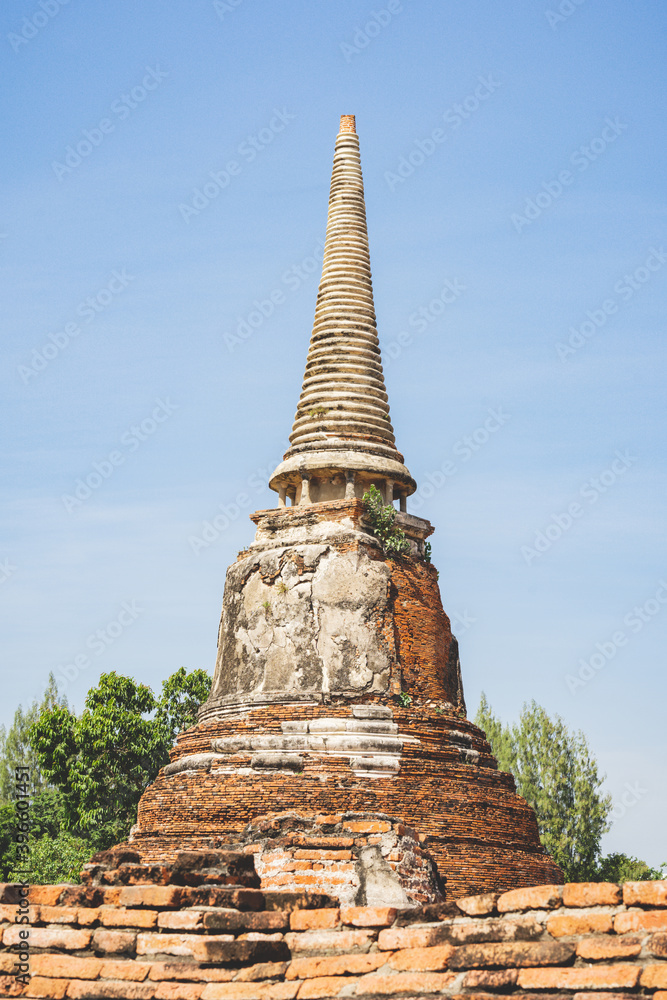An ancient pagoda in an old temple and a very old brick wall in Ayutthaya, Thailand.