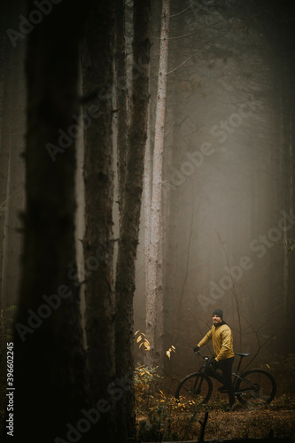 Young man taking a brake during biking through autumn forest © BGStock72