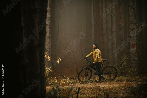 Wallpaper Mural Young man taking a brake during biking through autumn forest Torontodigital.ca