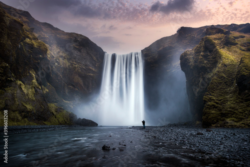 A man look at the Skogafoss Falls, in Iceland