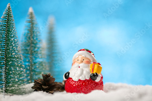 Winter background with Christmas trees and toy Santa Claus on a snow. © Ivan Karpov