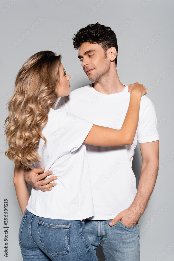 couple in white t-shirts hugging isolated on grey couple in white t-shirts hugging isolated on grey
