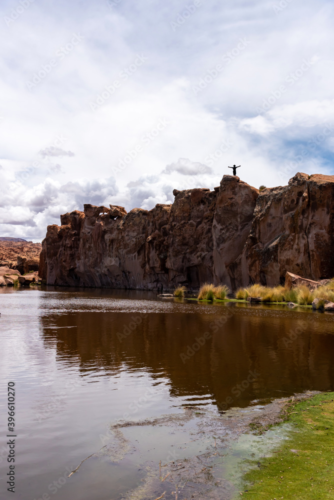 Man on top of a rock in a scenic lake in the southwest of the Bolivian altiplano