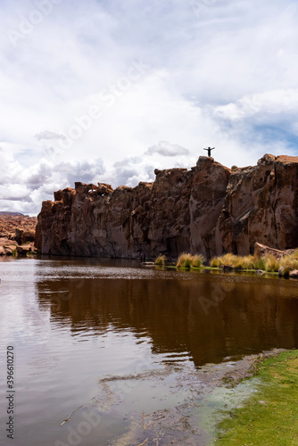 Man on top of a rock in a scenic lake in the southwest of the Bolivian altiplano