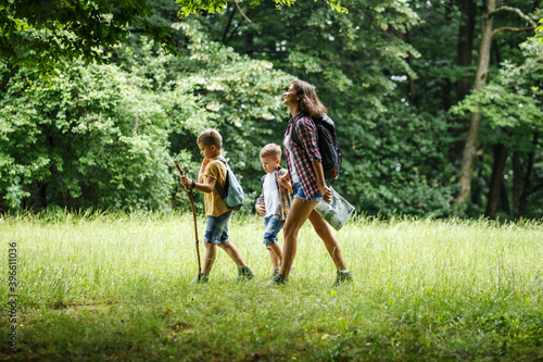 Фотография A mother and her two little sons embark on an adventurous hike through the serene forest, where they explore nature's wonders and create cherished family memories