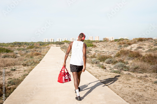 Young black athlete who walks away after training. Concept of sport.