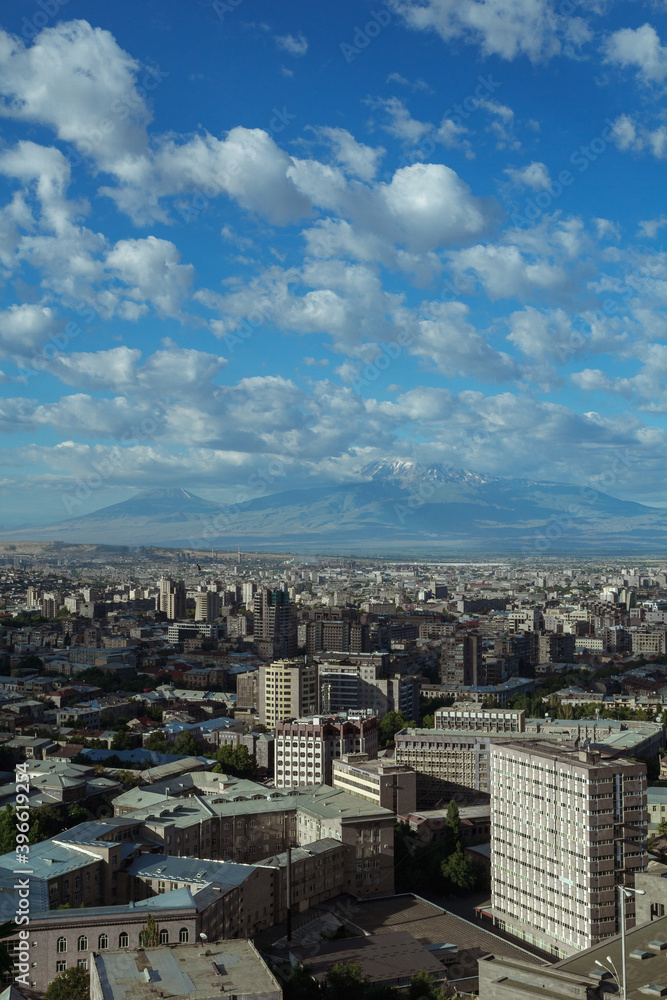 Majestic view of Yerevan city with buildings on background of mountains on sunny day 