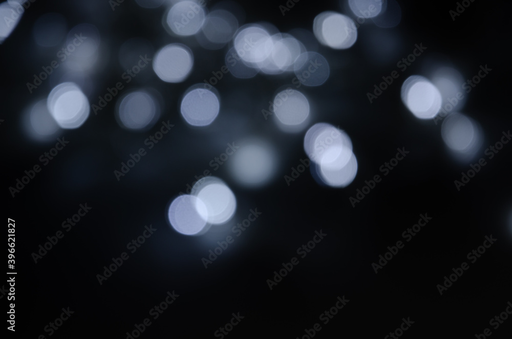 Abstract pattern of white bokeh lights on a dark background