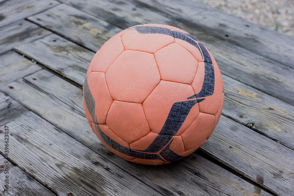 A soccer ball with a pattern lies on the wooden floor. A soccer ball with a pattern lies on the wooden floor.