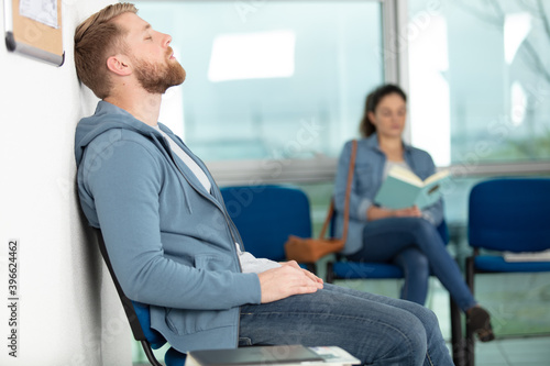 man sitting in doctors waiting room photo