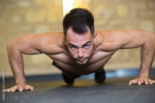 man with beautiful muscles are doing push-ups in the gym
