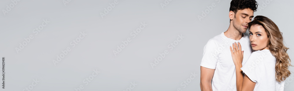 couple in white t-shirts posing isolated on grey, banner couple in white t-shirts posing isolated on grey, banner