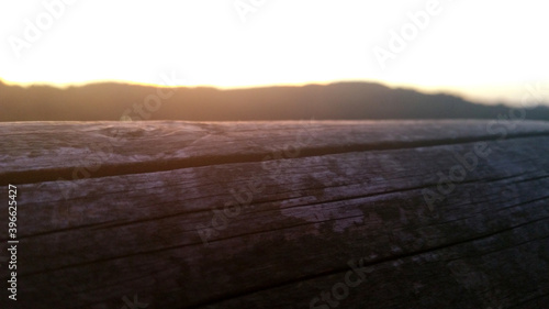 Close-up shot of wooden beam with sunset in the background