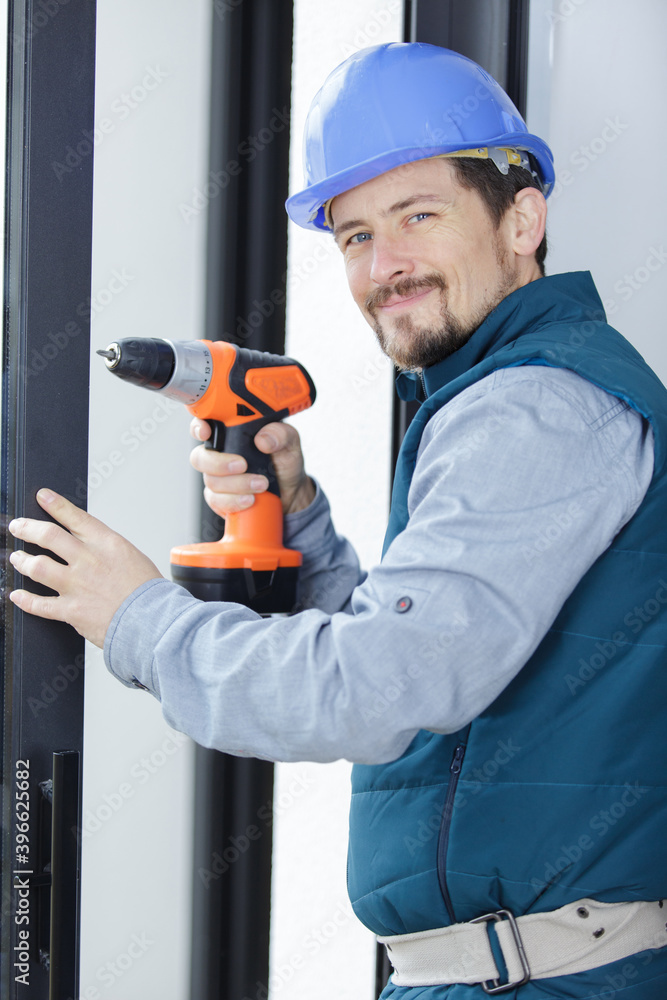 skilled professional using electric drill on the window skilled professional using electric drill on the window