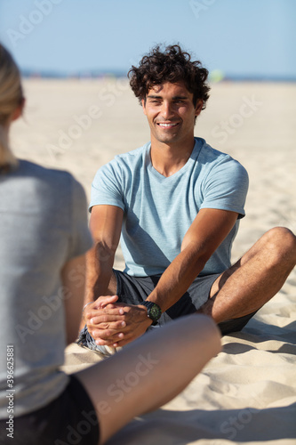 couple meditating on beach from back