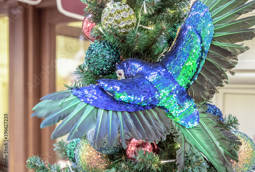 Fototapeta Naklejka Na Ścianę i Meble -  Macaw parrot with shiny outstretched wings on the Christmas tree.