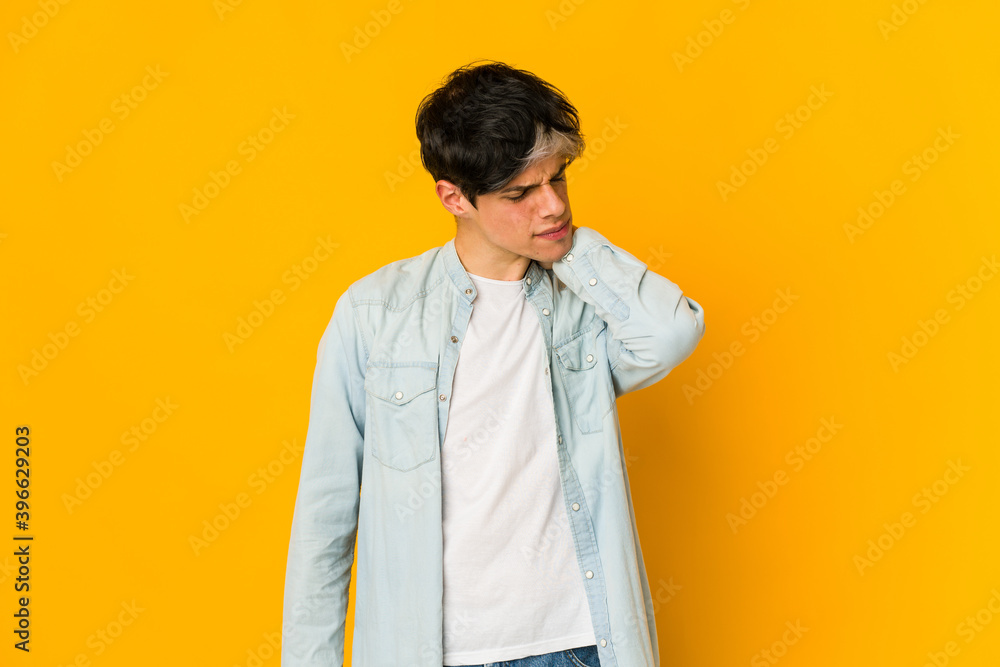Young skinny hispanic man having a neck pain due to stress, massaging and touching it with hand. Young skinny hispanic man having a neck pain due to stress, massaging and touching it with hand.