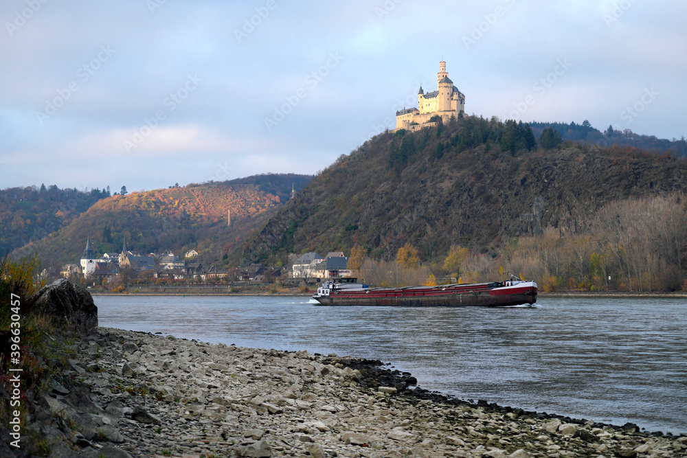 Der Rhein mit Niedrigwasser bei Braubach mit Binnenschiff und Marksburg - Stockfoto