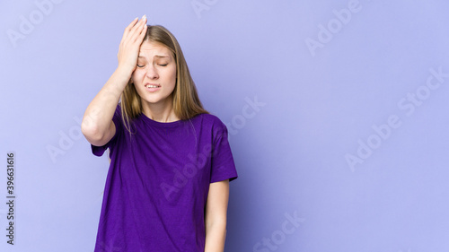Young blonde woman isolated on purple background forgetting something, slapping forehead with palm and closing eyes.
