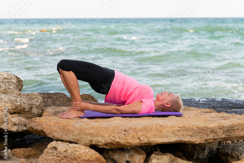 woman doing yoga exercises at the beach
