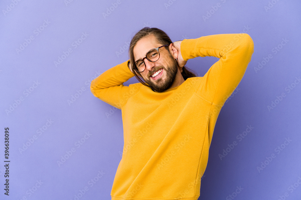Young man with long hair look feeling confident, with hands behind the head. Young man with long hair look feeling confident, with hands behind the head.
