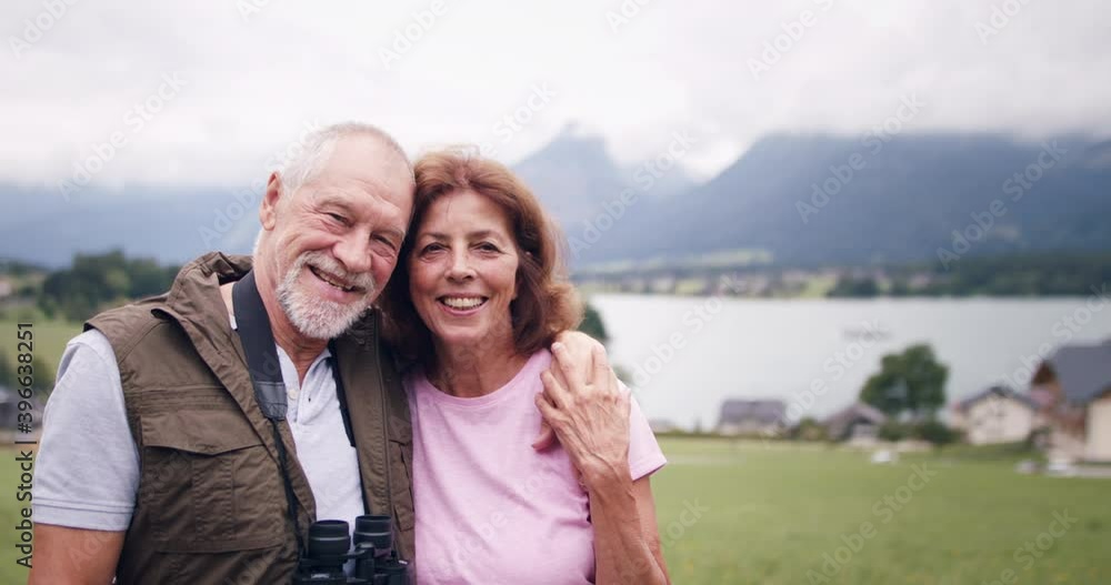 Senior pensioner couple hiking in nature, looking at camera. Senior pensioner couple hiking in nature, looking at camera.