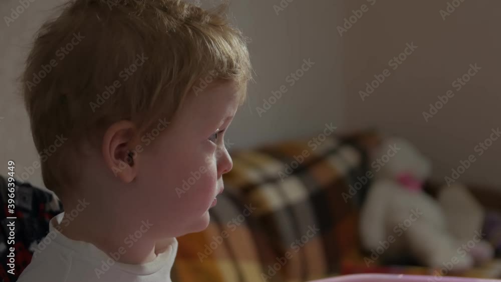 Little boy watching cartoons TV side view closeup evening interior Little boy watching cartoons TV side view closeup evening interior