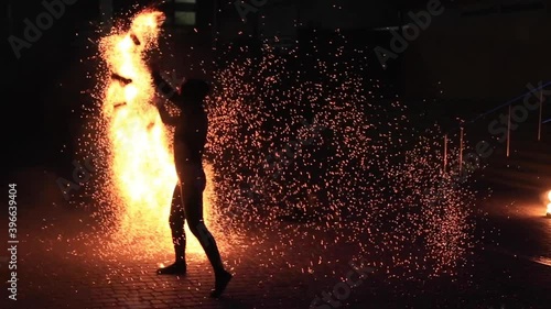Anonymous person dancing with fire at night