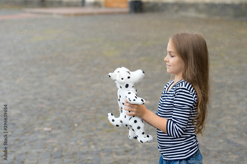 Φωτογραφία Little kid with long hair in casual fashion style play with toy dog outdoors, sh