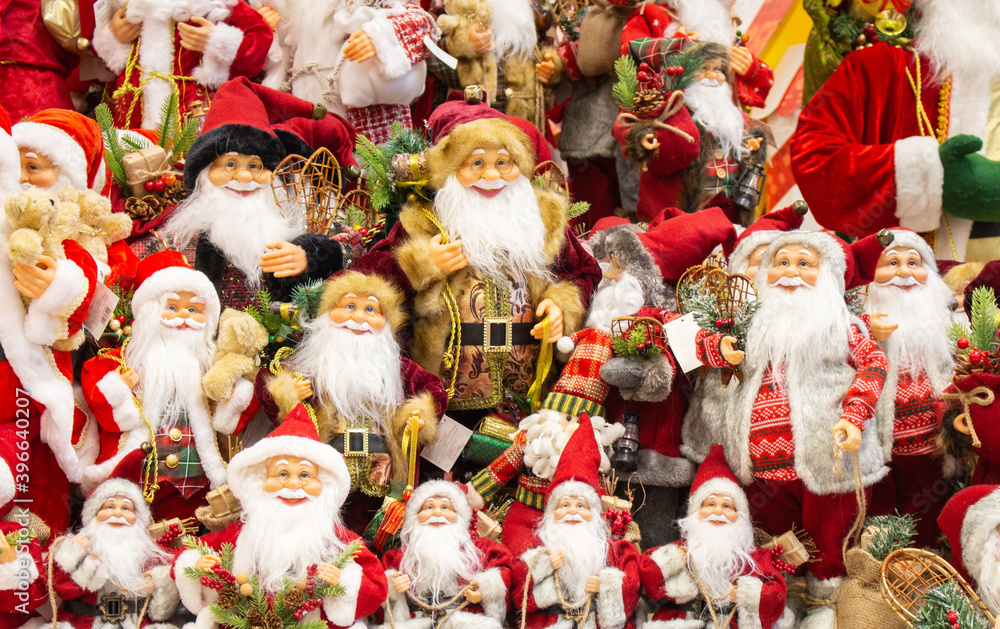 Many of Santa Claus with gifts. Santa Claus dolls. Christmas decoration. Santa Claus toy in store. Happy new year concept. Winter holidays festive decoration. Christmas magic. Festive shopping. 