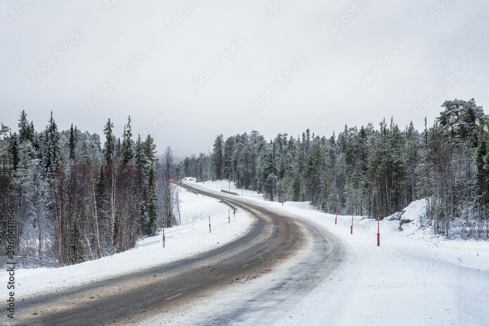 Fototapeta premium Empty snowy Northern winter road, turn on the road.