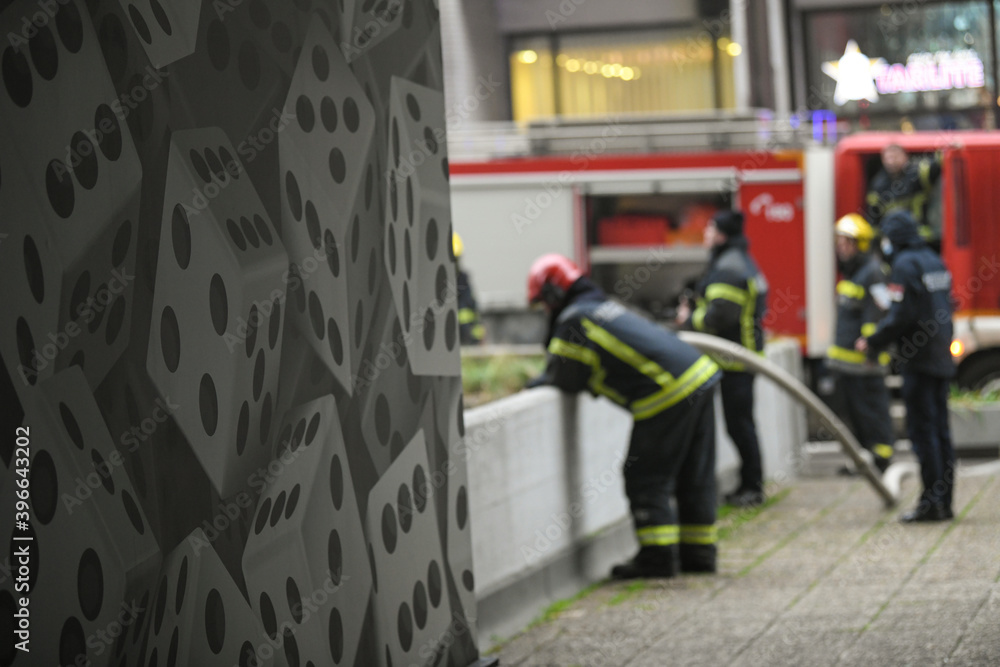 A photo of a firefighters from behind as they rest after putting out a large fire. A photo of a firefighters from behind as they rest after putting out a large fire.