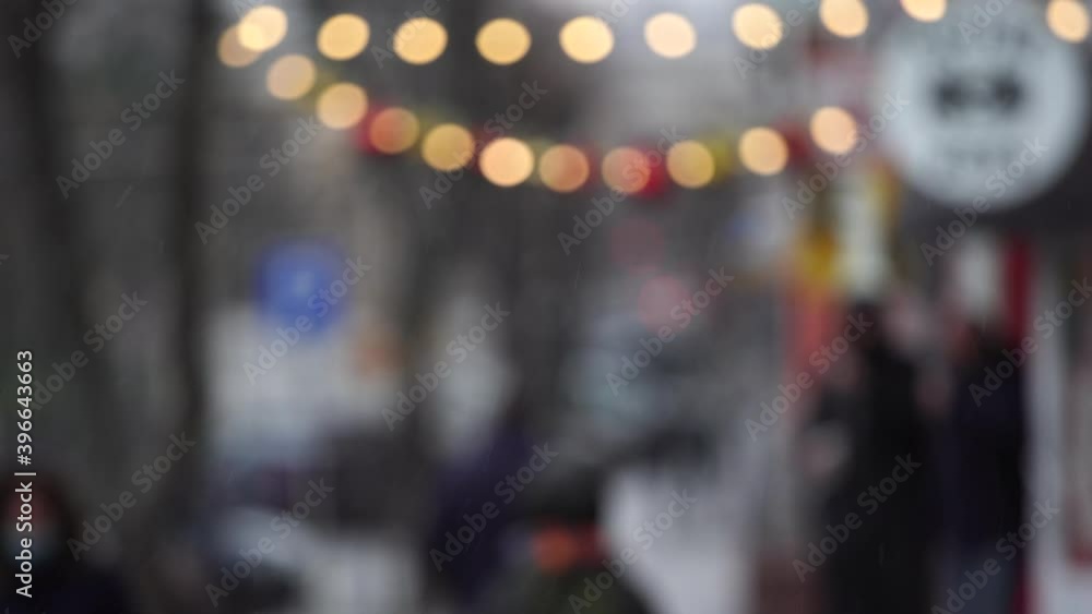 Blurry people walking quickly under snow in winter city. Bokeh 4k video background. Blurry people walking quickly under snow in winter city. Bokeh 4k video background.