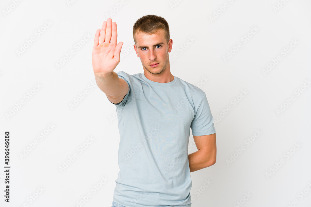 Young caucasian handsome man standing with outstretched hand showing stop sign, preventing you. Young caucasian handsome man standing with outstretched hand showing stop sign, preventing you.
