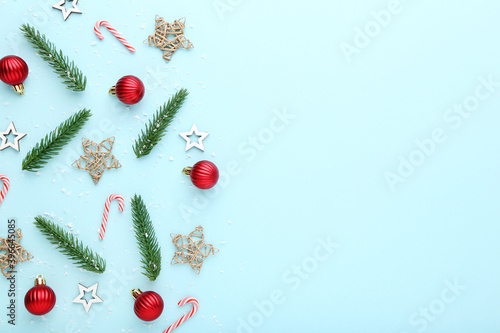 Christmas composition. Fir tree branches with ornaments on blue background
