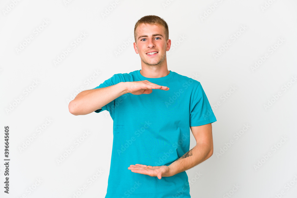 Young caucasian handsome man holding something with both hands, product presentation. Young caucasian handsome man holding something with both hands, product presentation.