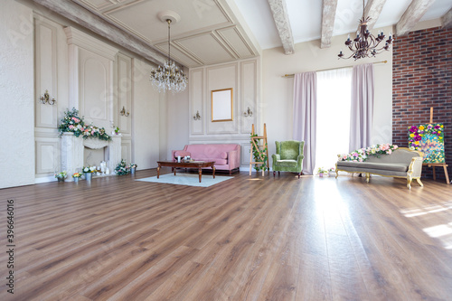 Bright cozy living room design. Wooden floor, fresh flowers and white columns on the walls © 4595886