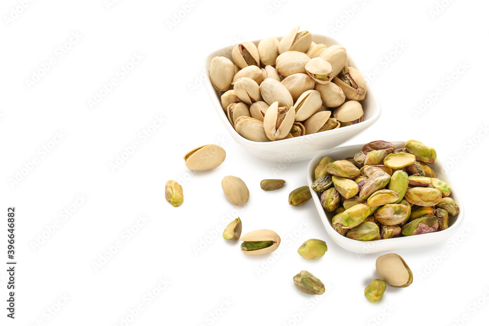 Tasty pistachios in bowls on white background Tasty pistachios in bowls on white background
