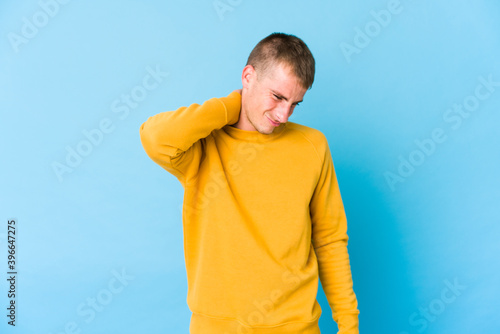 Young caucasian handsome man suffering neck pain due to sedentary lifestyle.