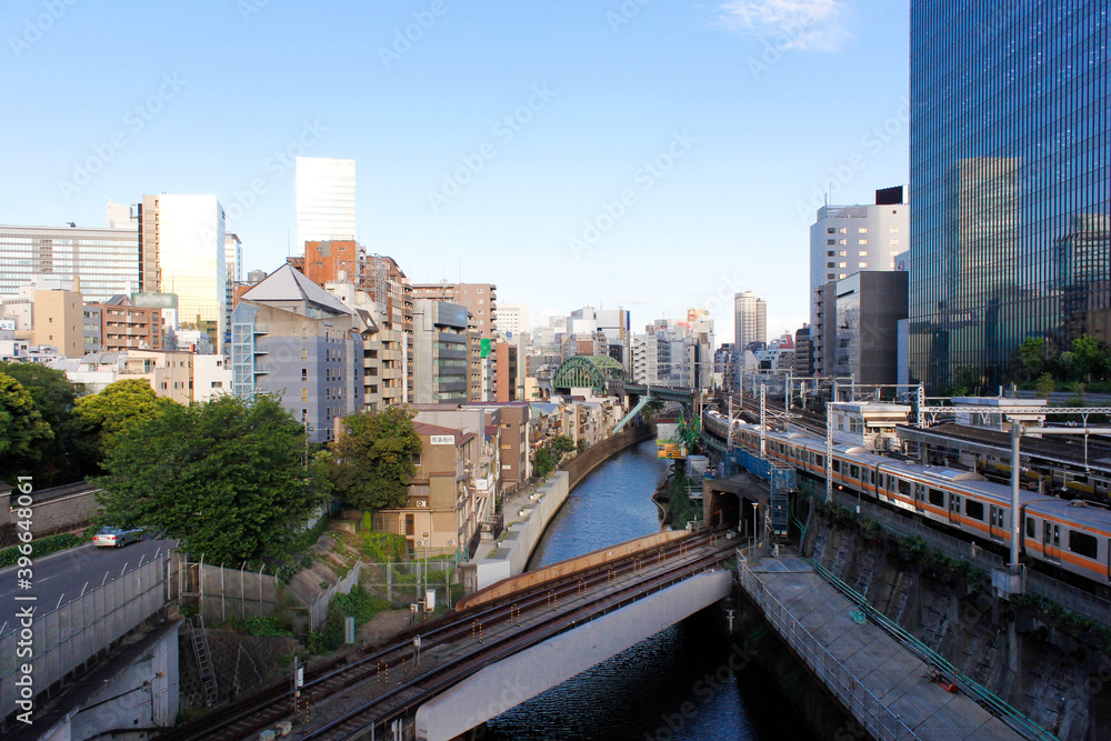 Obraz premium Central Tokyo. Urban cityscape, train tracks, small houses, skyscrapers made out of glass and metal. Travel concept. Tokyo, Japan.
