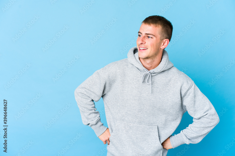 Young caucasian handsome man laughs happily and has fun keeping hands on stomach. Young caucasian handsome man laughs happily and has fun keeping hands on stomach.