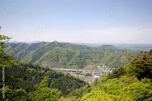 Japanese mountains. View on train tracks. Blue sky on a sunny spring day. Green leaves. Travel concept. Close to Tokyo, Japan.