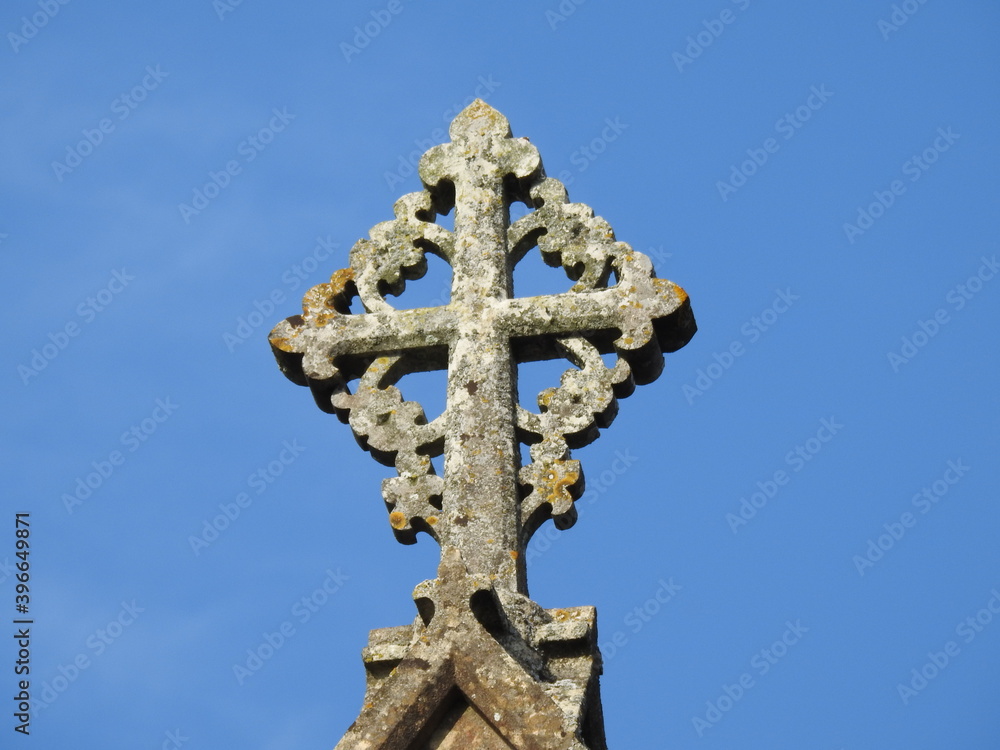 A stone artistic cross on the roof of the church