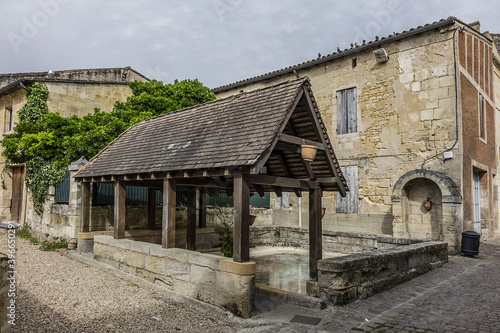 View of old Washhouse with King's Fountain (Fontaine du Roi). Washhouse - public pond (19th century), where washerwomen washed linen or rather rinsed it. Saint Emilion, Gironde, France.