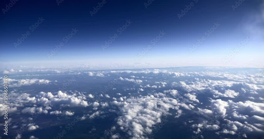 View on Cloudy Blue Sky through Porthole Window in Passenger Jet. Airplane Flying Above Clouds View on Cloudy Blue Sky through Porthole Window in Passenger Jet. Airplane Flying Above Clouds