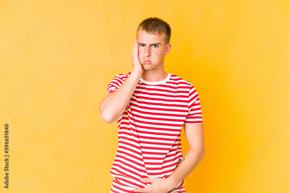 Young caucasian handsome man blows cheeks, has tired expression. Facial expression concept. Young caucasian handsome man blows cheeks, has tired expression. Facial expression concept.