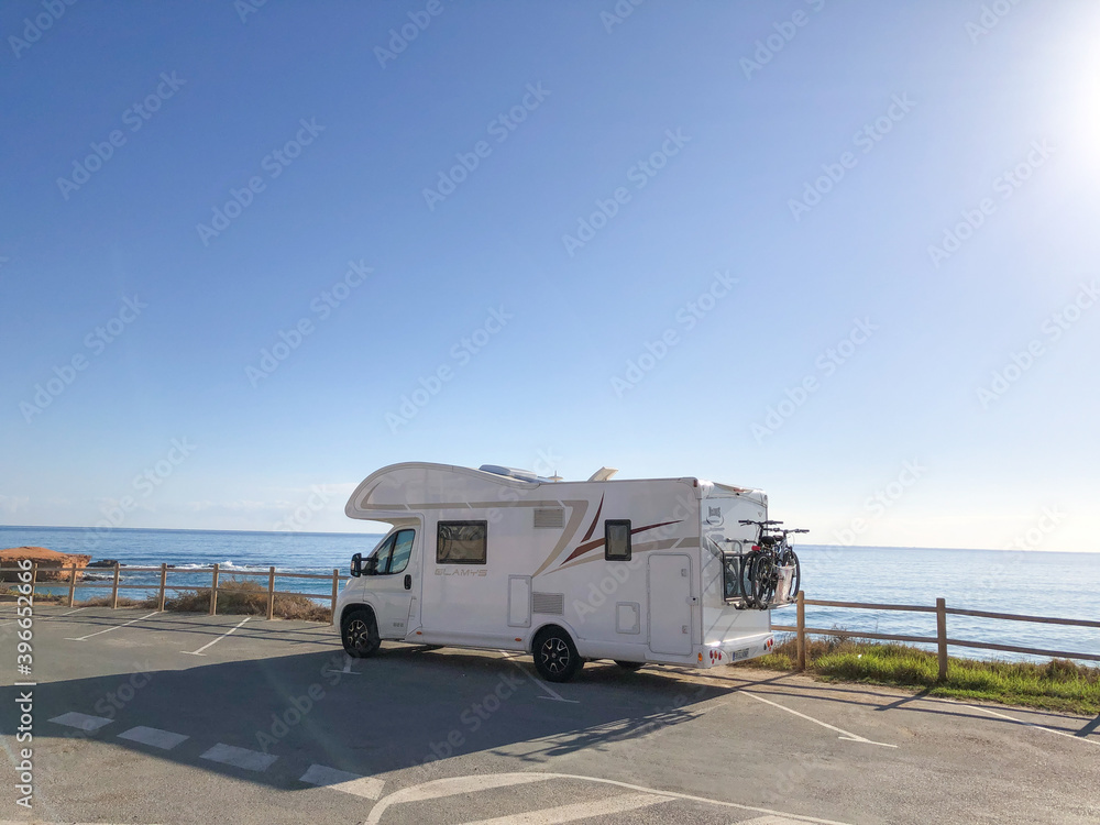 Alicante, Spain - November, 2020: Big family auto house parked next to sea on empty parking with beautiful view to the beach Alicante, Spain - November, 2020: Big family auto house parked next to sea on empty parking with beautiful view to the beach