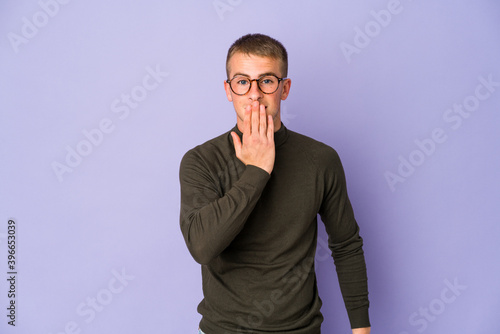 Young caucasian handsome man shocked, covering mouth with hands, anxious to discover something new.
