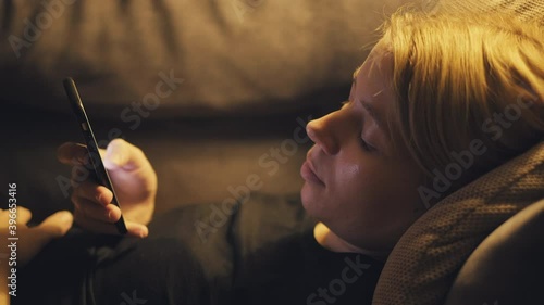 Woman using smartphone and lying on sofa 